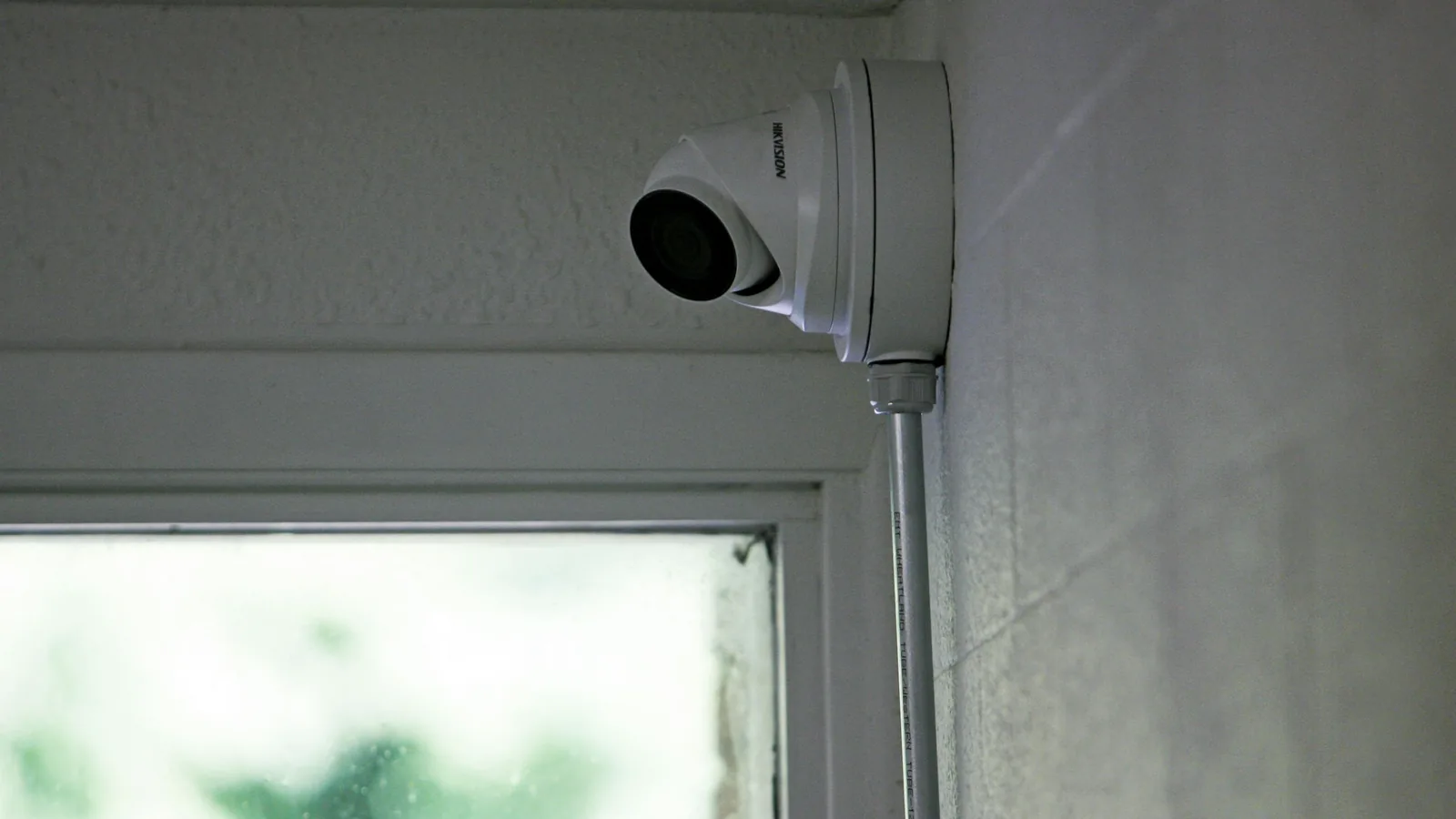 A security camera mounted above a residential window