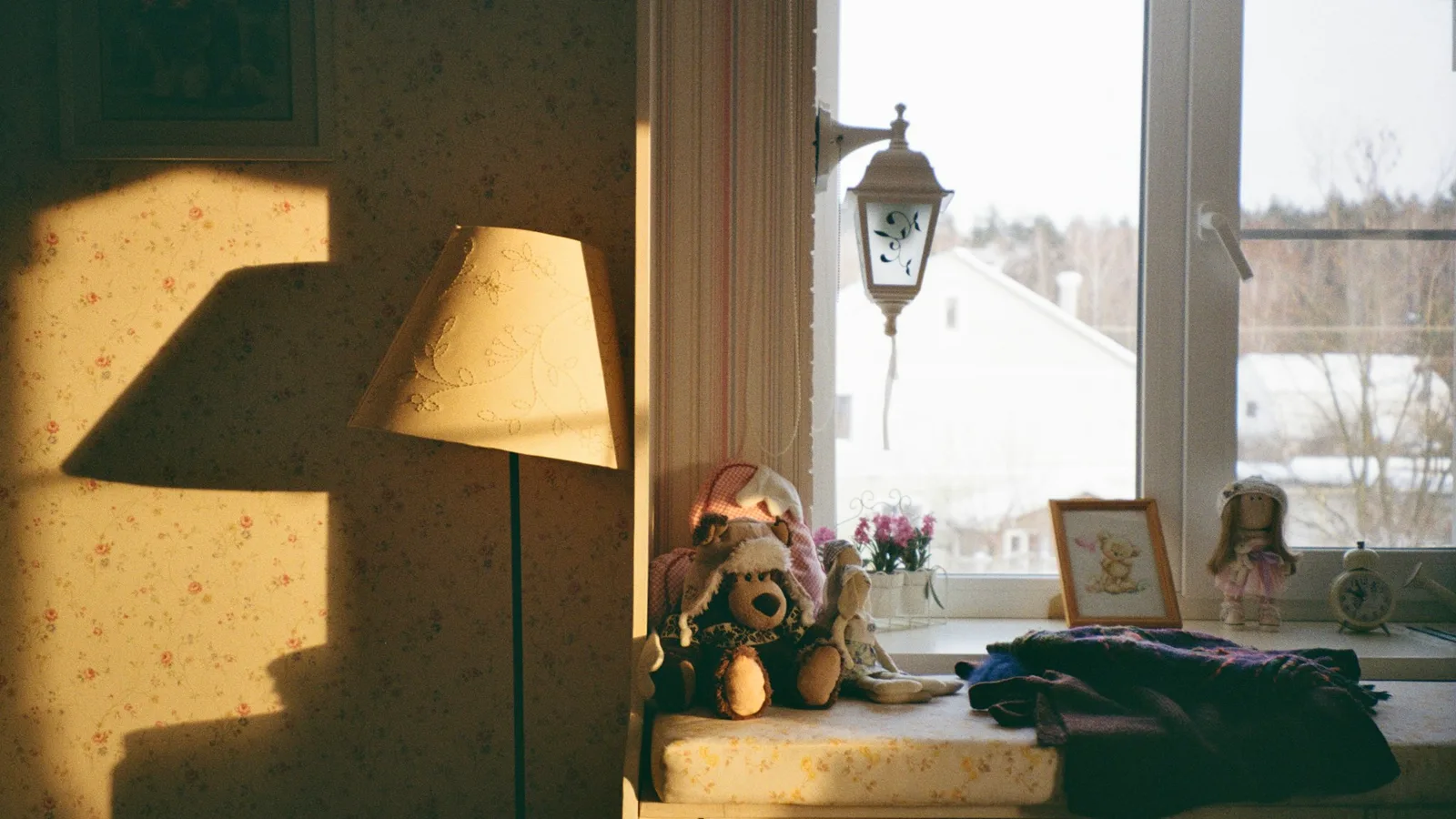 Toys and a lamp beside a sunlit window