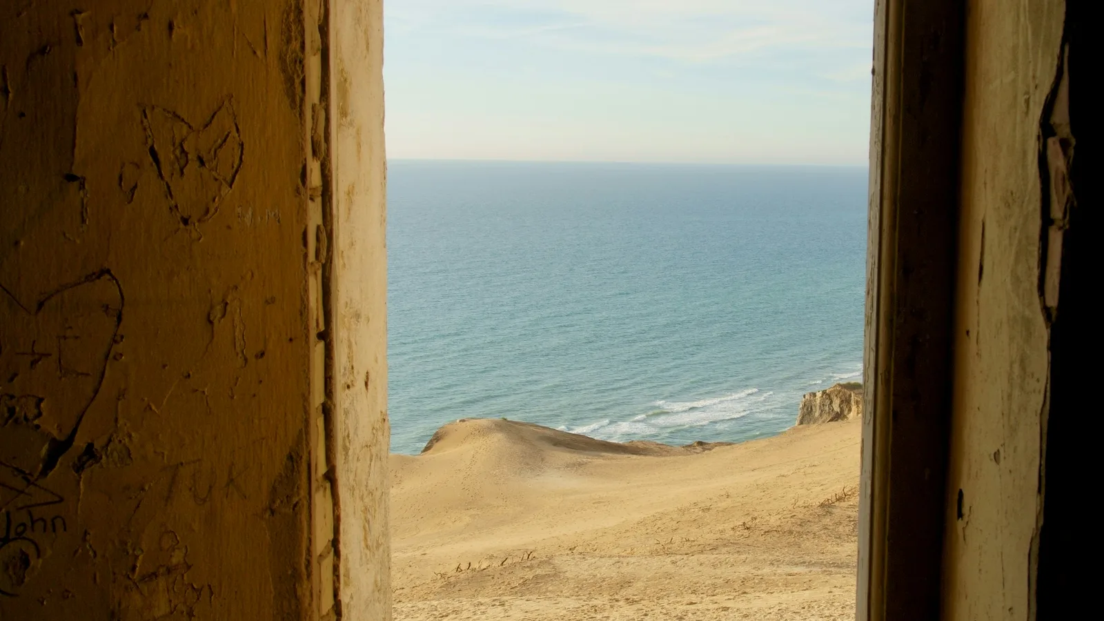 Ocean visible through a framed opening on a coastal bluff