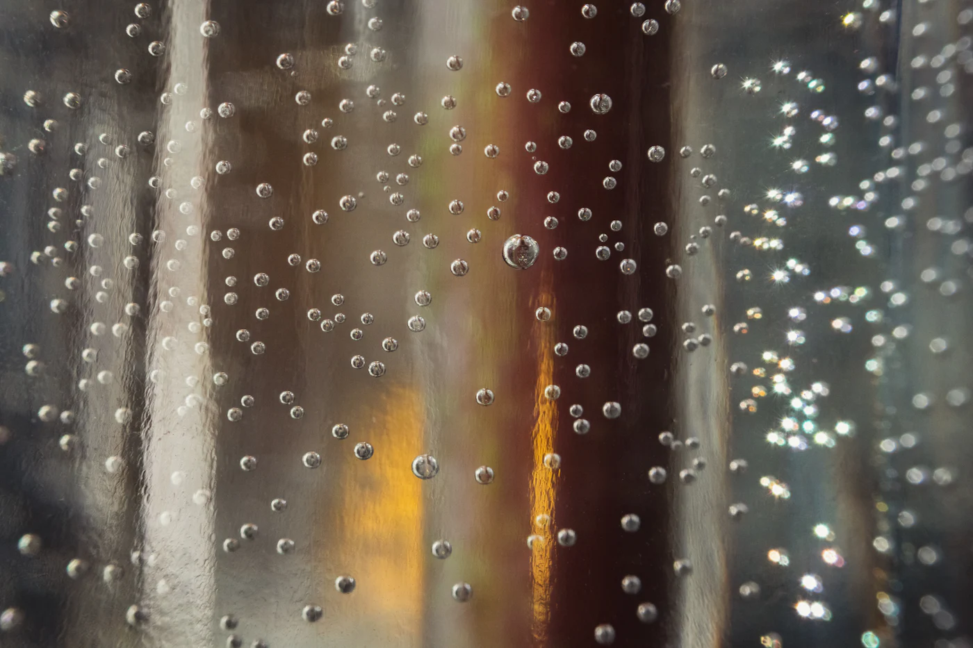 Water droplets covering a glass surface, illustrating condensation on a window