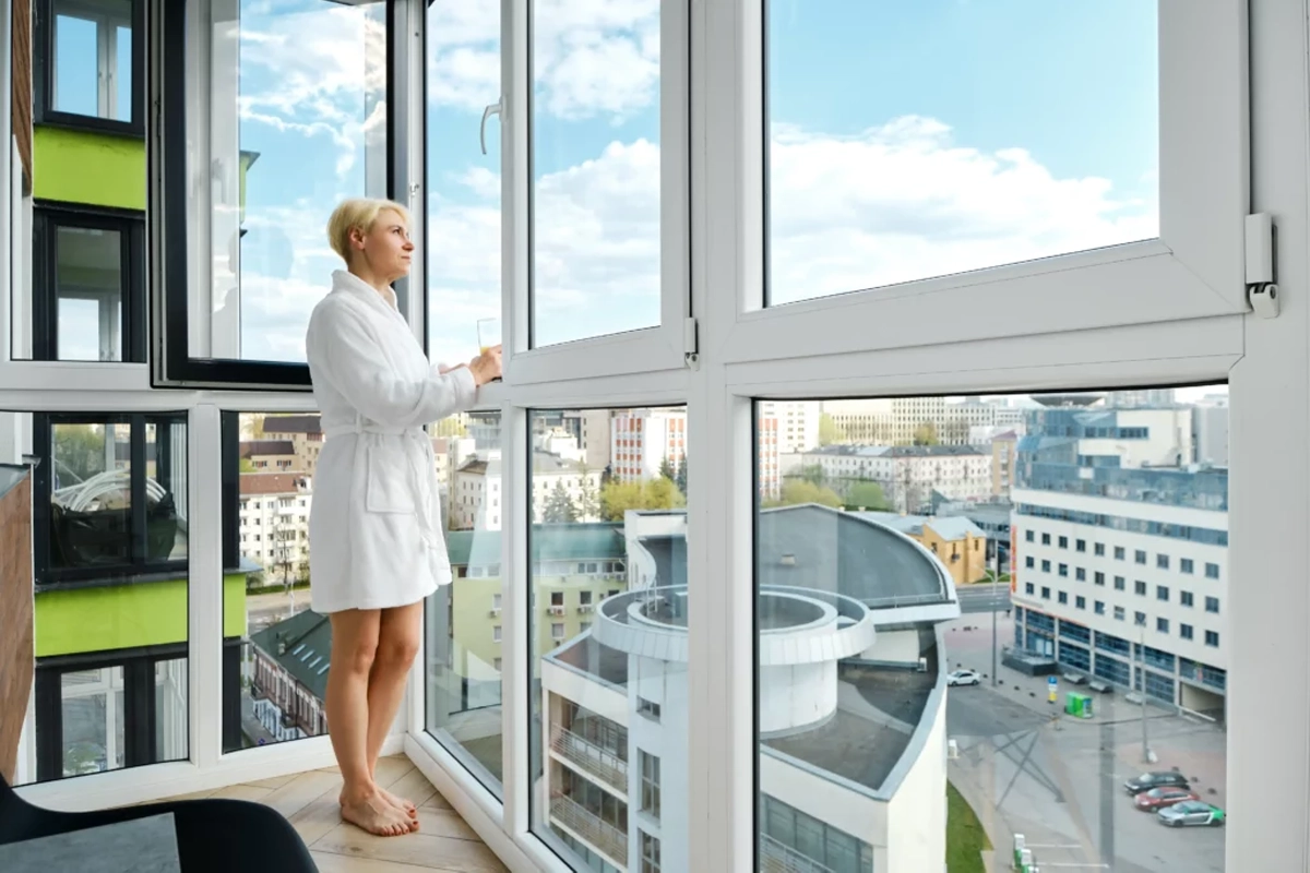 A woman looking at the windows at home