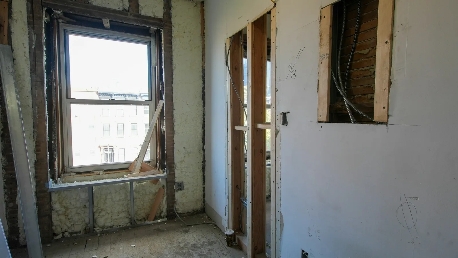 Room renovation with exposed framing around a tall window