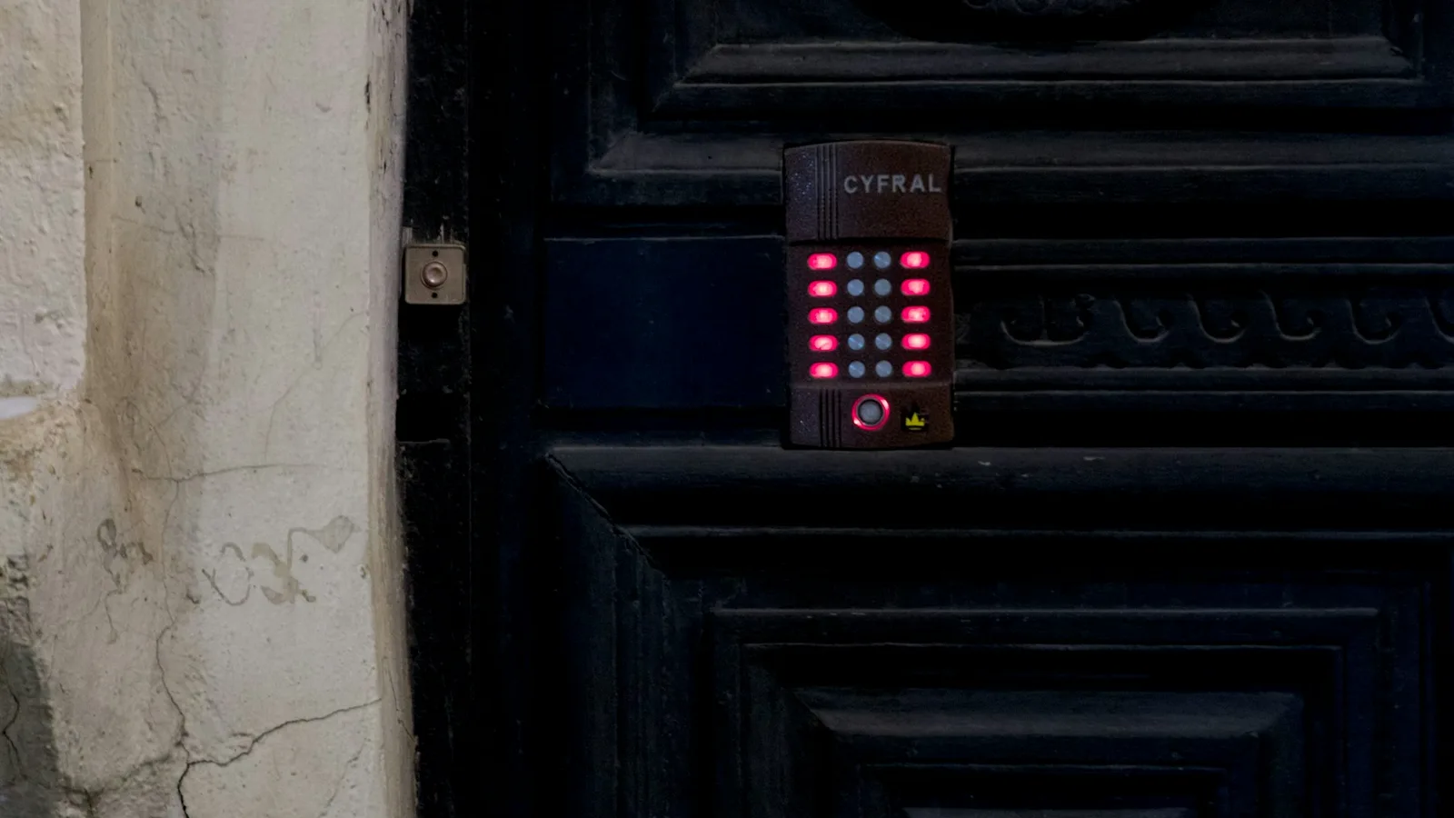 A keypad mounted on a dark paneled door